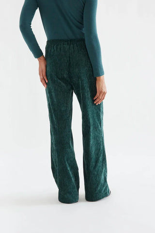 Dark green velvet trousers with a jewel button