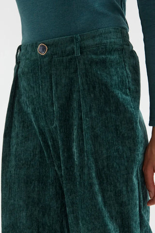 Dark green velvet trousers with a jewel button