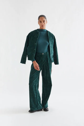 Dark green velvet trousers with a jewel button