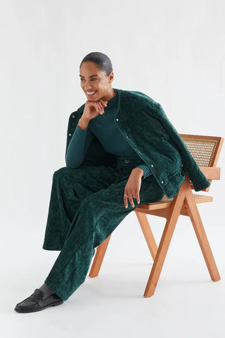 Dark green velvet trousers with a jewel button